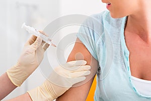 Woman at doctor getting vaccination syringe photo