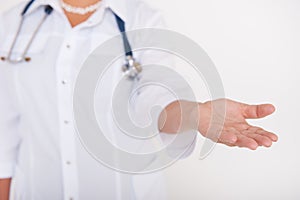 Woman doctor giving helping hand isolated on white