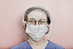 Woman doctor on a grey background. Concept of the fight against coronavirus. Face girl nurse in a blue uniform