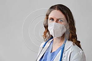 Woman doctor on a grey background. Concept of the fight against coronavirus. Face nurse in a blue uniform