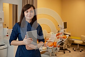 Woman doctor gynecologist with clipboard in her clinic office photo