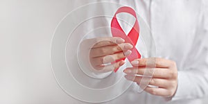 woman doctor hand holding pink ribbon breast cancer awareness in october. concept healthcare and medicine banner with copy space