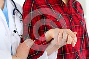 Woman doctor hands holding female child patient hand