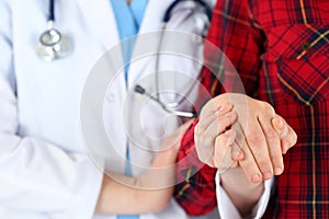 Woman doctor hands holding female child patient hand