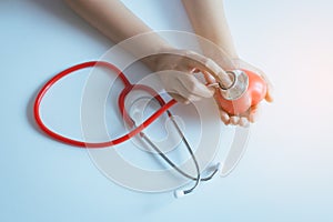 Woman doctor hands holding stethoscope to checking red heart from patient,Health care checking concept