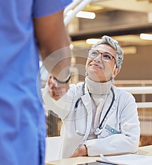 Woman, doctor and handshake with nurse for teamwork, partnership or thank you for healthcare service, meeting or