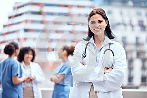 Woman, doctor and happy portrait outdoor with arms crossed at hospital, clinic or colleagues on rooftop for a break