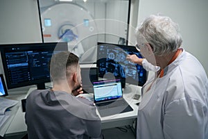 Woman doctor and her colleague are analyzing results of CT photo