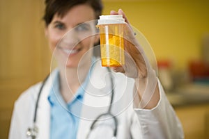 Woman Doctor holding bottle of pills