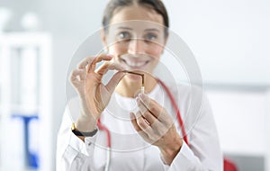 Woman doctor holding broken cigarette in clinic closeup