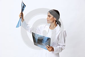 Woman doctor holding X-ray in robe on white background, consequences of covid-19, pneumonia and lung damage, concept of