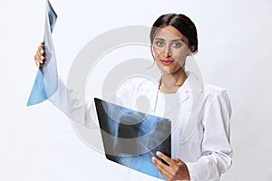 Woman doctor holding X-ray in robe on white background, consequences of covid-19, pneumonia and lung damage, concept of