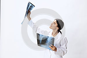 Woman doctor holding X-ray in robe on white background, consequences of covid-19, pneumonia and lung damage, concept of