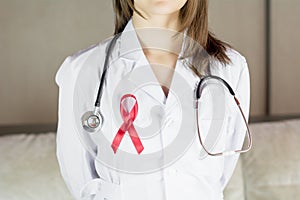 Woman doctor holding red ribbon HIV, world AIDS day awareness ribbon