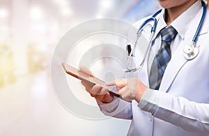 Woman doctor holding tablet and pointing index finger to screen