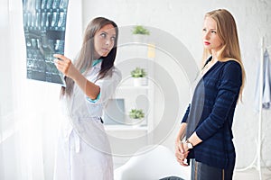 Woman doctor in hospital looking at x-ray film