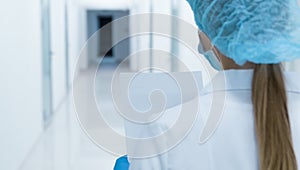 Woman doctor looking at medical history in empty medical corridor