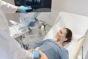 Woman and doctor looking at ultrasonic screen during examination