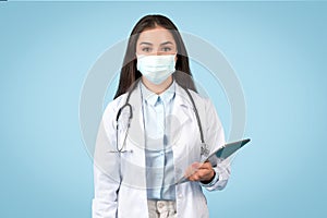 Woman doctor with mask holding digital tablet