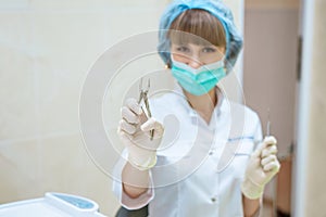 Woman doctor in mask with tools in hand