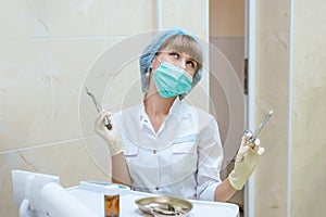 Woman doctor in mask with tools in hand