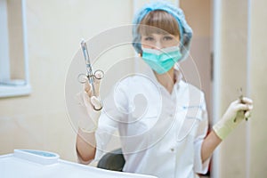 Woman doctor in mask with tools in hand