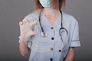 Woman doctor in medical mask and gloves. close-up. holds an ampoule with a vaccine in his hands. covid