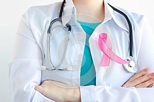 Woman doctor in medical white uniform with pink ribbon. Breast Cancer Awareness Month. Women& x27;s health care concept