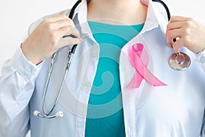 Woman doctor in medical white uniform with pink ribbon. Breast Cancer Awareness Month. Women& x27;s health care concept