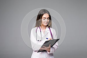 Woman doctor or nurse with clipboard with blank paper on grey background