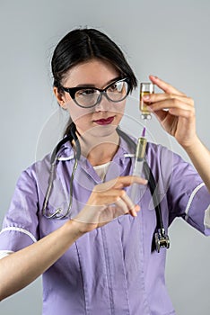 woman doctor or nurse in white med uniform and gloves with syringe in hands on isolated