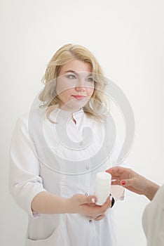 A woman doctor with pleasant appearance passes the patient vitamins (medicines). The patient is in good hands.