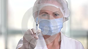 Woman doctor preparing syringe for injection.