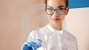 Woman doctor preparing syringe for injection. Female doctor or nurse holding syringe with liquid close up. Medicine and