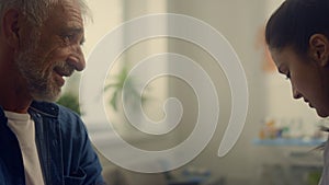 Woman doctor putting cuff measuring blood pressure on old man arm close up.