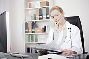 Woman Doctor Reading Medical Reports at her Office