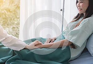 Women doctor reassuring her female asian patient in hospital room,Dentist giving a consultation and encouragement to patient toget