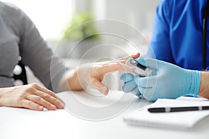 A woman at a doctor`s appointment during the coronavirus epidemic. Doctor checking oxygenation with fingertip pulse oximeter.