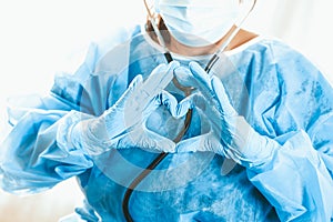 Woman doctor shows heart with hands. Doctor`s love for patients. Doctor for the heart. Concept of Covid-19 quarantine. Medical