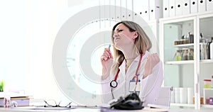 Woman doctor singing into microphone at end of working day in clinic 4k movie slow motion