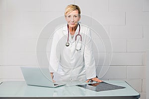 Woman doctor standing behind desk