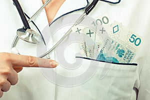 Woman doctor with stethoscope showing polish currency money in apron pocket