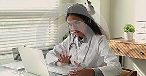 Woman doctor talking to patient using video call and laptop