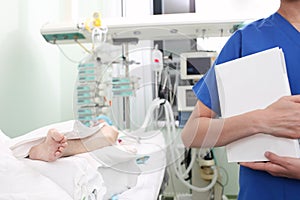 Woman doctor with a thick book in a hospital ward, near the patient