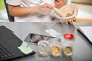 Woman doctor using a mortar and pestle