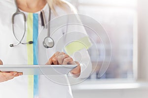 Woman doctor using tablet computer in hospital photo