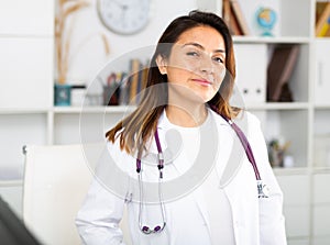 Woman doctor wear white medical uniform and stethoscope look at camera posing in clinic