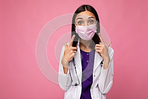 Woman Doctor Wearing Medical Mask White Coat and Stethoscope isolated on background wall