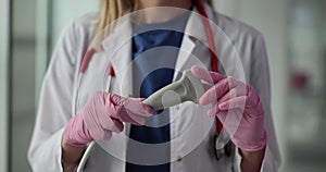 Woman doctor in work uniform holds ultrasound transducer device