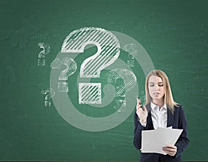 Woman with documents and questions on blackboard